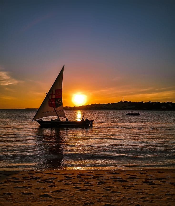 Traditional dhow boat sailing at sunset