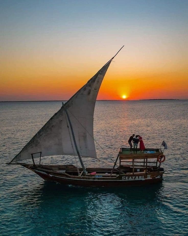 Traditional dhow boats on turquoise water at golden hour